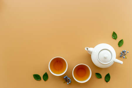 White teapot and cups of black tea with leaves, top viewの写真素材
