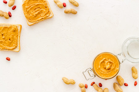 Peanut butter sandwiches and creamy butter in glass jar, top view