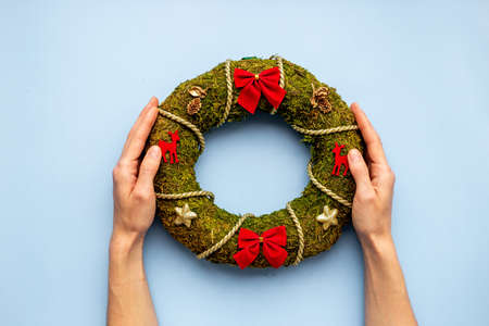Woman hands holding Christmas wreath with fir tree, top viewの写真素材