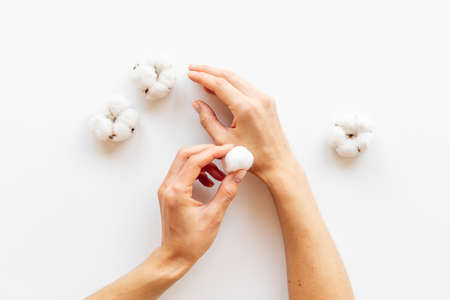 Cotton wool balls in female hands - clean and care for skinの写真素材