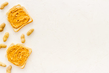 Breakfast with peanut butter sandwiches on white bread, top view