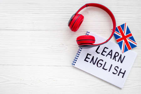 Headpones with notebook on student table desk. Online language coursesの写真素材