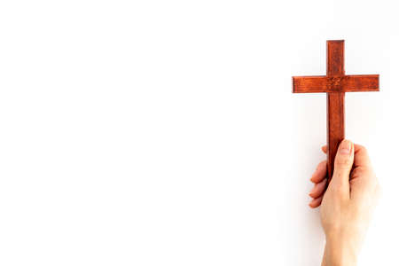 Female hands holding christian wooden cross. Faith and prayer concept.の写真素材