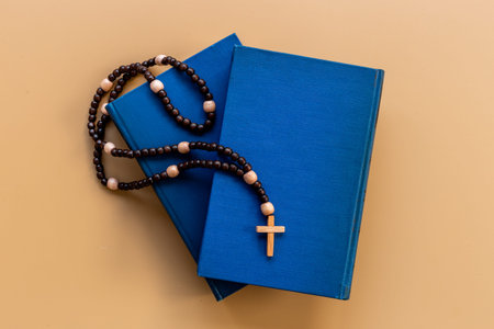 Rosary beads with cross on Bible book. Faith and prayer concept