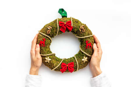 Female hands holding festive Christmas wreath. New year decoration backgroundの写真素材