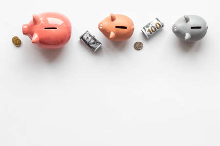 Many piggy bank - different types of currency saving and investmentsの写真素材