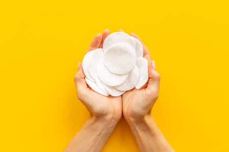 Female hands holding cotton pads for cleansing skin and care