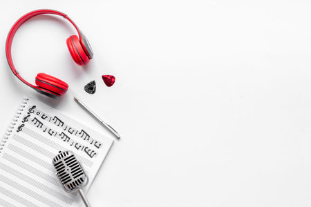 Music sheets with musical notes and headphones, top view