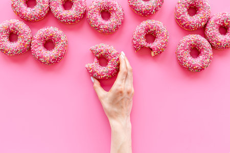 Set of pink glazed donuts with sprinkles, top view