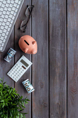 Piggy bank on office table with keyboard and calculator. Financial planning conceptの写真素材