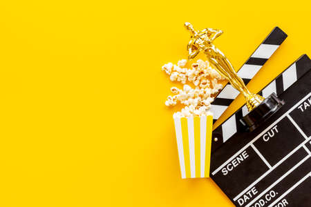 Golden film award statue with clapper board and popcornの写真素材