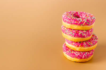 Close up of pink frosted donuts with colorful sprinkles