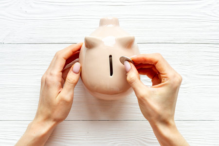 Piggy bank in hands top view. Family budget concept