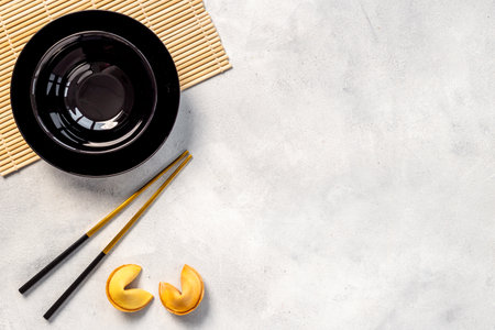 Asian style table place setting with fortune cookies and golden chopsticksの写真素材