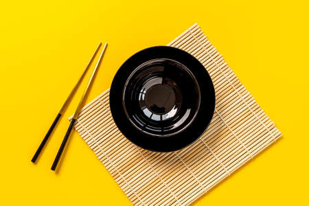 Black bowl with golden chopsticks for Asian table place settingの写真素材