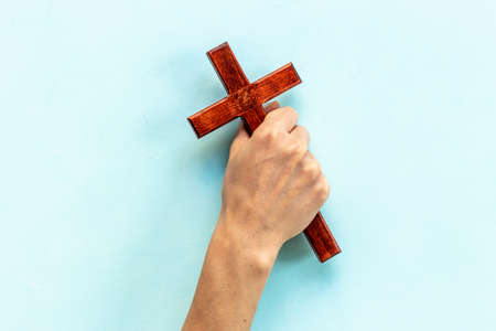 Christian wooden cross in hands. Faith and prayer conceptの写真素材