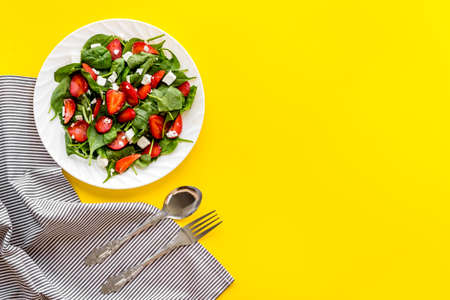 Green spinach salad with red strawberry and goat cheese top viewの写真素材