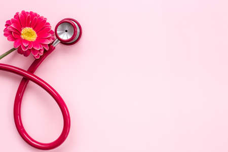 Breast cancer awareness concept with red flower and stethoscopeの写真素材