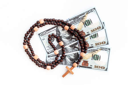 Dollars with religion rosary and wooden cross. Religion concept