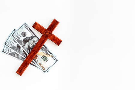 Money and religion. Wooden cross on dollars