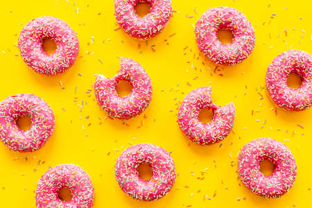 Set of pink glazed donutes with sprinkles, top viewの写真素材