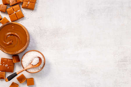 Bowl of caramel sauce and toffee candies with sea salt, top viewの写真素材
