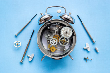 Watchmaker tools near watch mechanism of alarm clockの写真素材