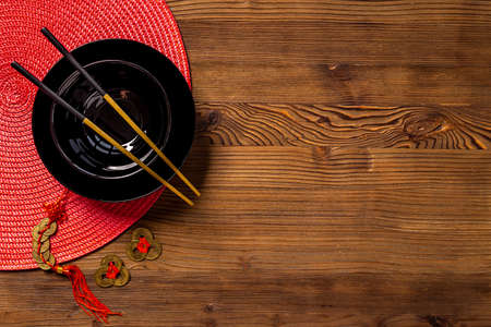 Black and gold chopsticks with red mat. Asian table place setting
