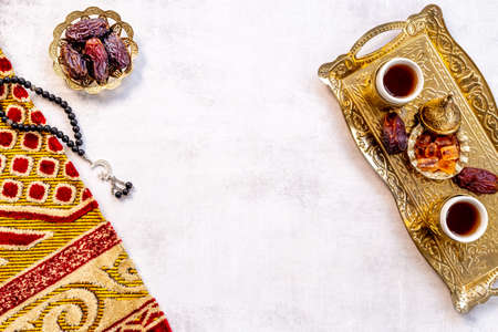 Ramadan Kareem concept. Islamic prayer carpet with rosary and dried fruitsの写真素材