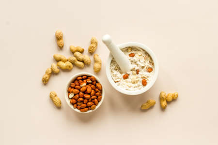 Pestle peanut flour - nuts with mortar on kitchen table.の写真素材