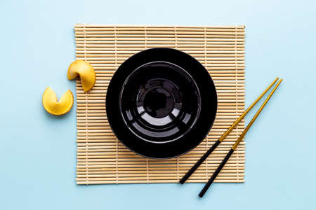 Black bowl with golden chopsticks for Asian table place setting.の写真素材