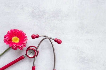 Breast cancer diagnosis with red stethoscope and flower