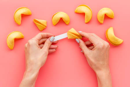 Female hands open Chinese fortune cookie. Chinese New Year backgroundの写真素材