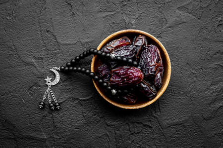 Ramadan concept. Black islamic rosary with crescent with dates fruitsの写真素材