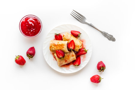 Sweet breakfast - rolled pancakes with strawberry and berry sauceの写真素材