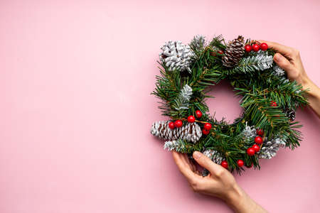 Woman hands holding Christmas wreath with fir tree, top viewの写真素材