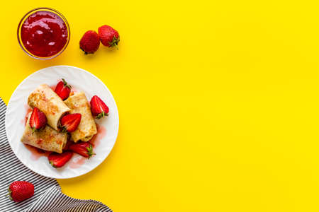 Sweet breakfast - rolled pancakes with strawberry and berry sauce