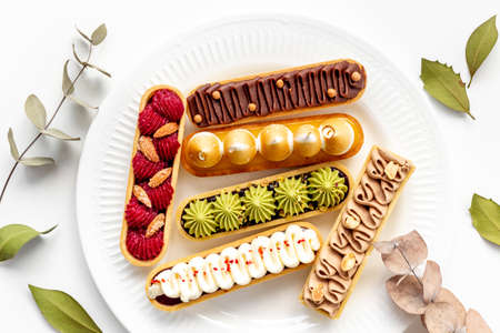 Set of french dessert eclairs with colorful toppingの写真素材