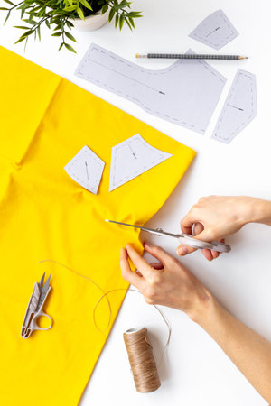 Workplace of seamstress. Hands doing sewing patterns with fabric