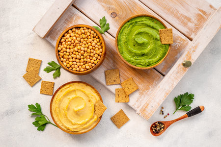 Flatlay of vegetarian hummus in bowls with chickpeas
