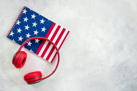 Notebook with USA flag and headphones. English lessons concept