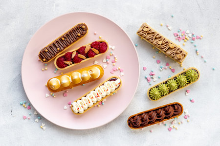 Top view of sweet bakery eclairs with color topping