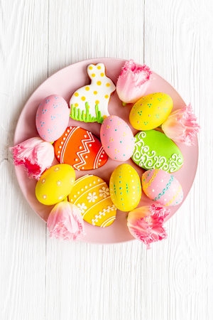 Happy Easter background with eggs and gingerbread cookies, top view