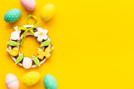 Happy Easter background with eggs and gingerbread cookies, top view
