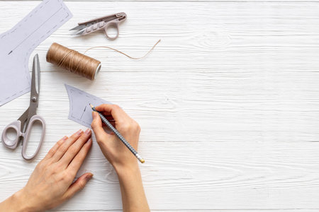 Female hands holding sewing patterns. Sewing background for dress workshop