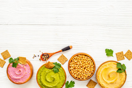 Various types of hummus in bowls. Hummus with spinach and beets