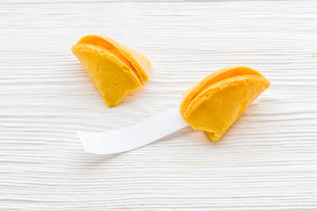 Broken Chinese fortune cookie with blank slip outside