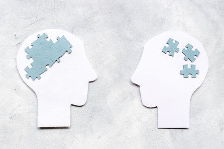 Communication. Chaos and peace in brain - two paper human heads with puzzles
