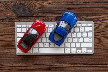 Car for sale concept. Toy car near computer keyboard