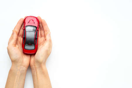 Car insurance or driving safety concept. Toy car in handsの写真素材